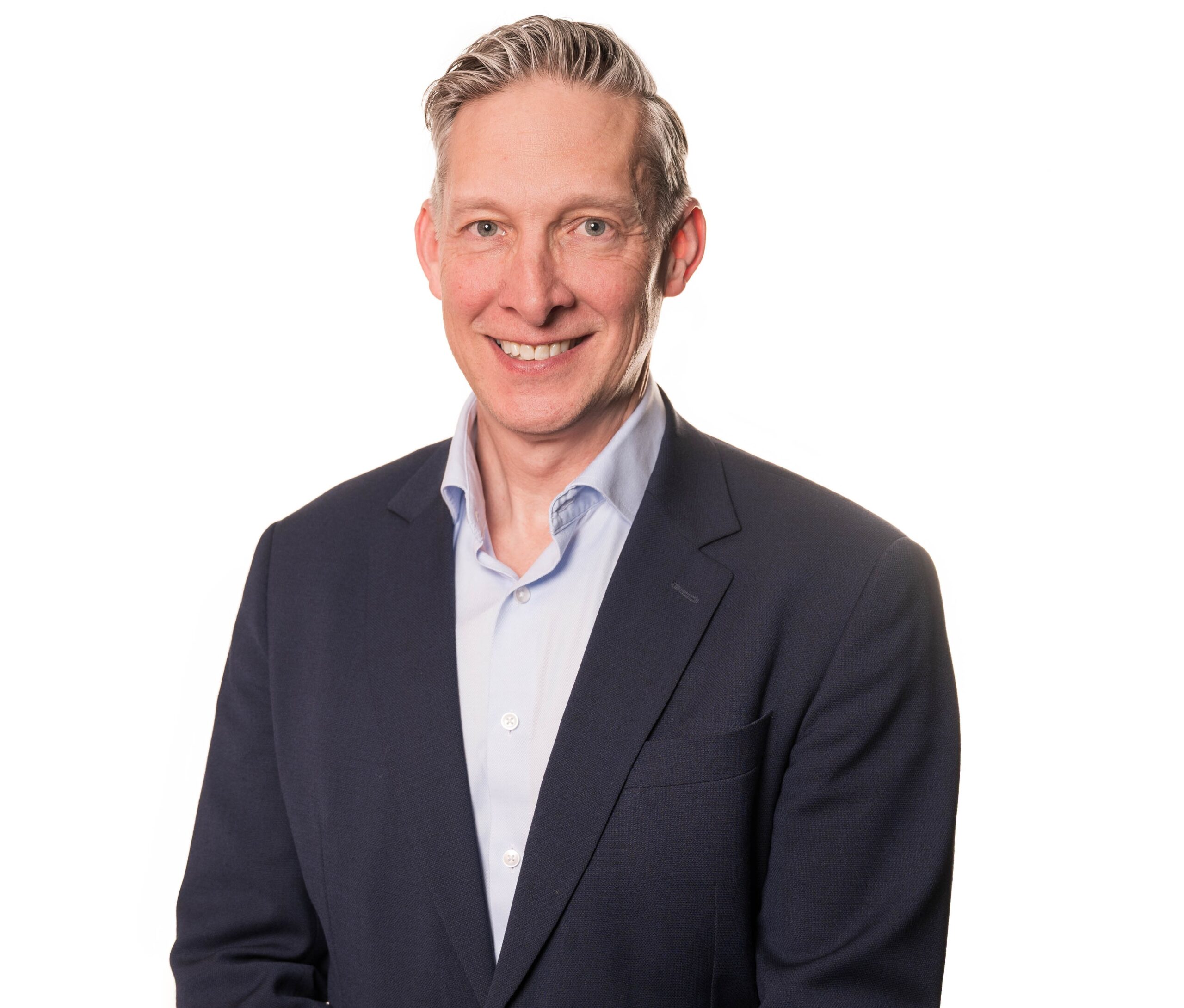 Professional headshot of a smiling man in a suit and light blue shirt.