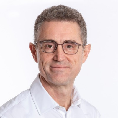 Tom Bindloss_Photo Man wearing glasses and white shirt smiling for a photo