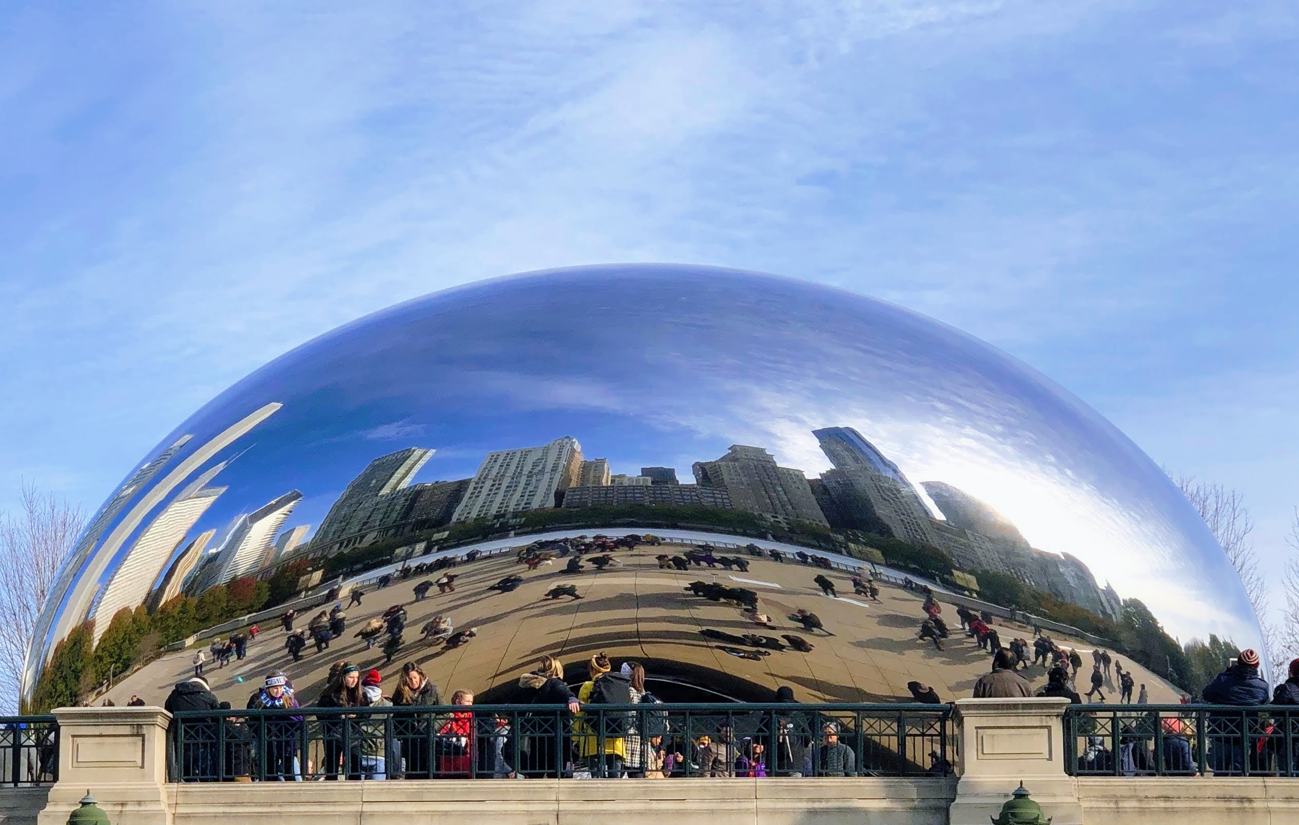 People admire the Chicago skyline reflected in the Cloud Gate sculpture