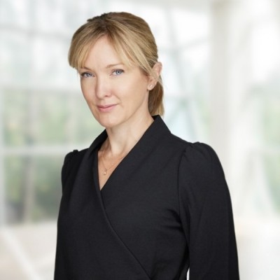 Treasury leaders roundtable with woman in black wrap blouse standing in London office