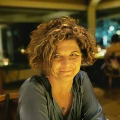 Treasury leader with curly hair smiles in a restaurant setting.