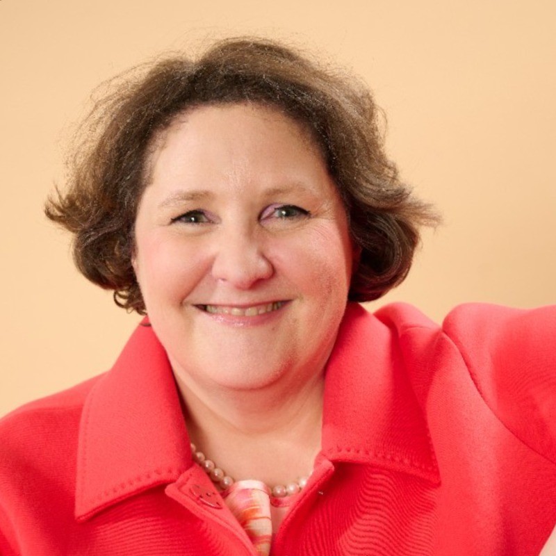 Severine Le Blevennec_Photo Treasury Careers Podcast guest, a smiling woman in a coral jacket.