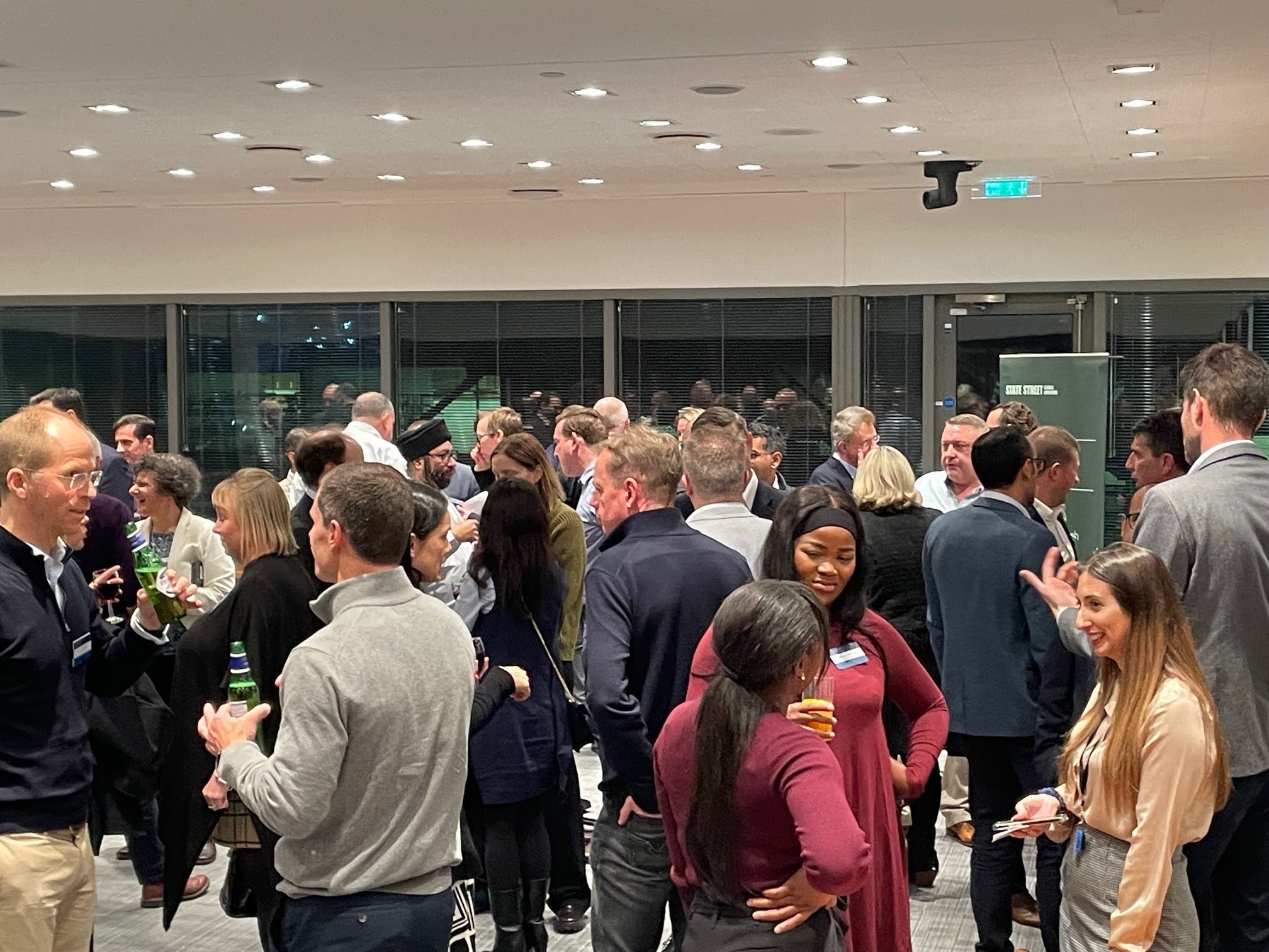 Group of people networking at an event with sponsorship drinks
