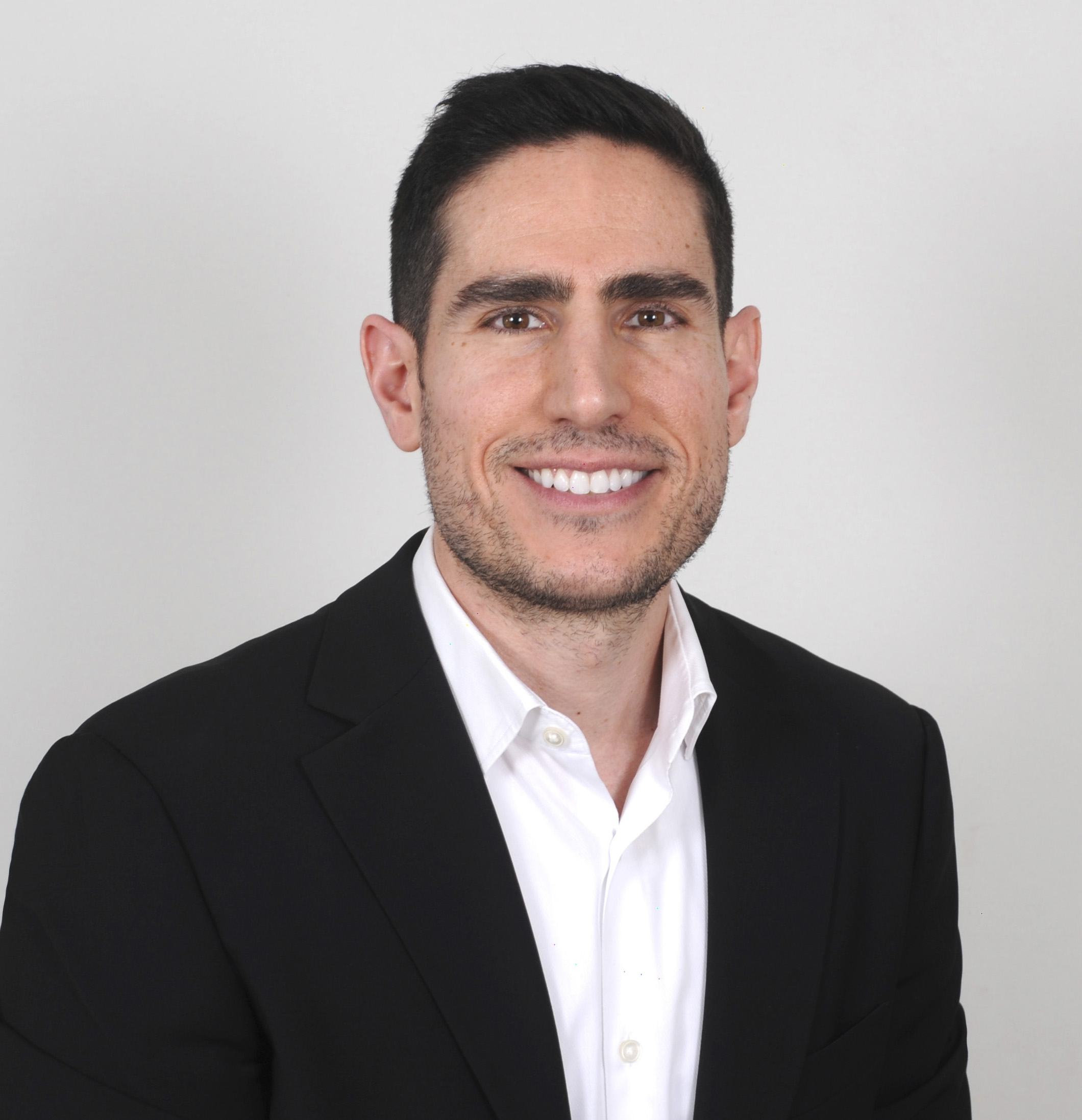 Antonios Reizopoulos_Photo Podcast guest smiling in a black suit and white shirt
